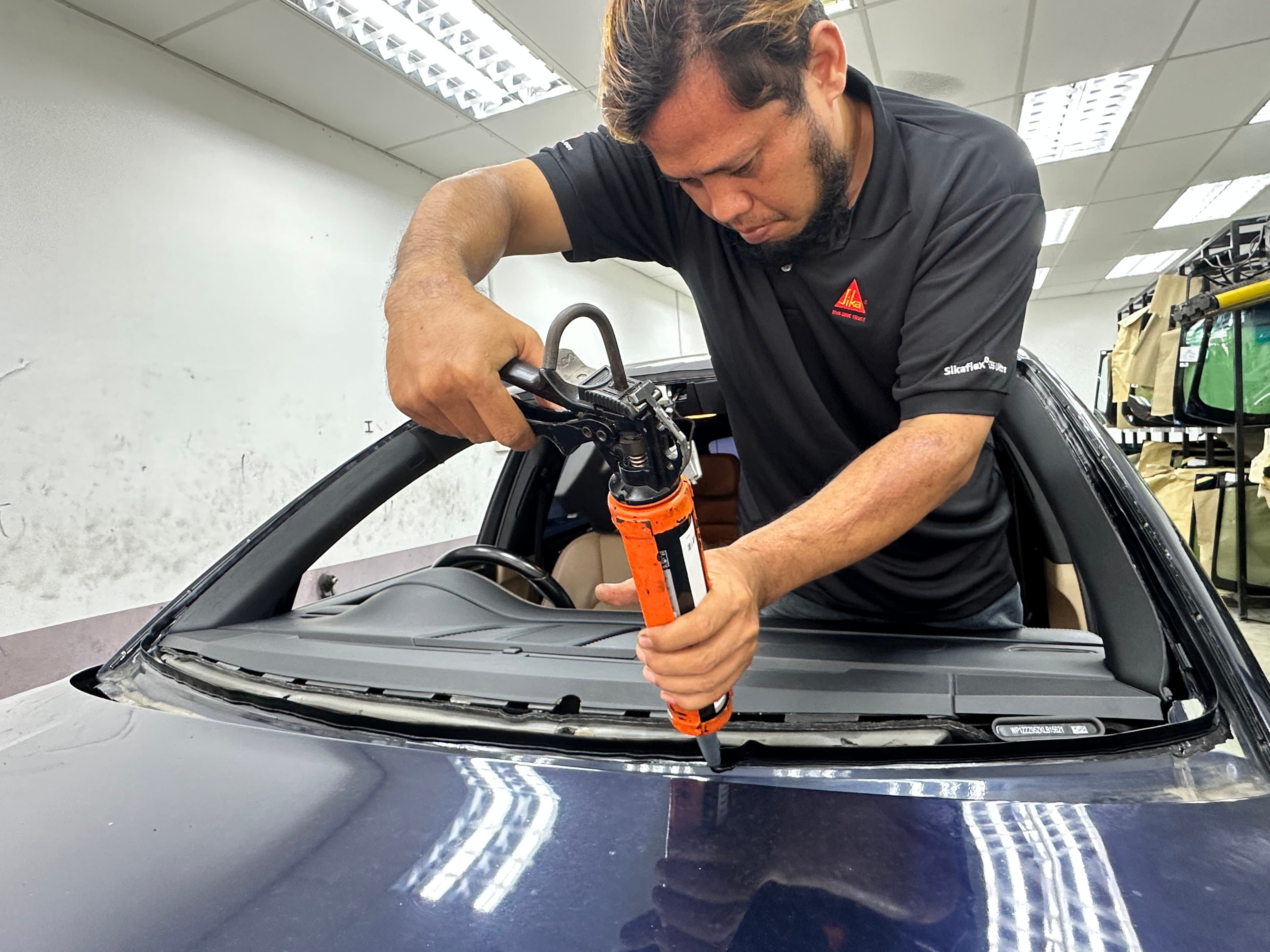 Adhesive application during windscreen replacement at SIFU CERMIN Senawang HQ